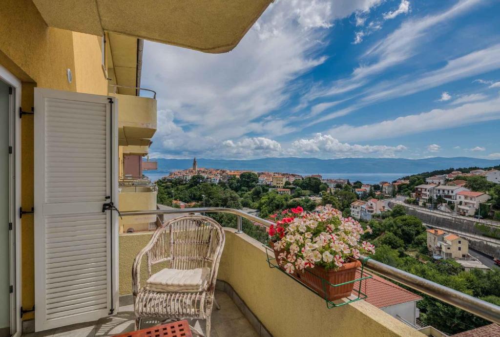 einen Balkon mit einem Stuhl und Stadtblick in der Unterkunft Apartment in Vrbnik - Insel Krk 47401 in Vrbnik