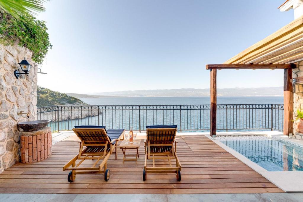 a deck with chairs and a table and a pool at Holiday home in Vrbnik - Insel Krk 45251 in Vrbnik
