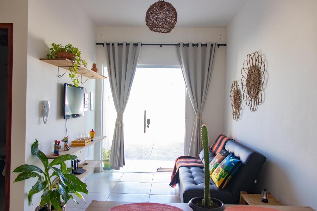 a living room with a couch and a large window at Vila Girassol in Aracaju