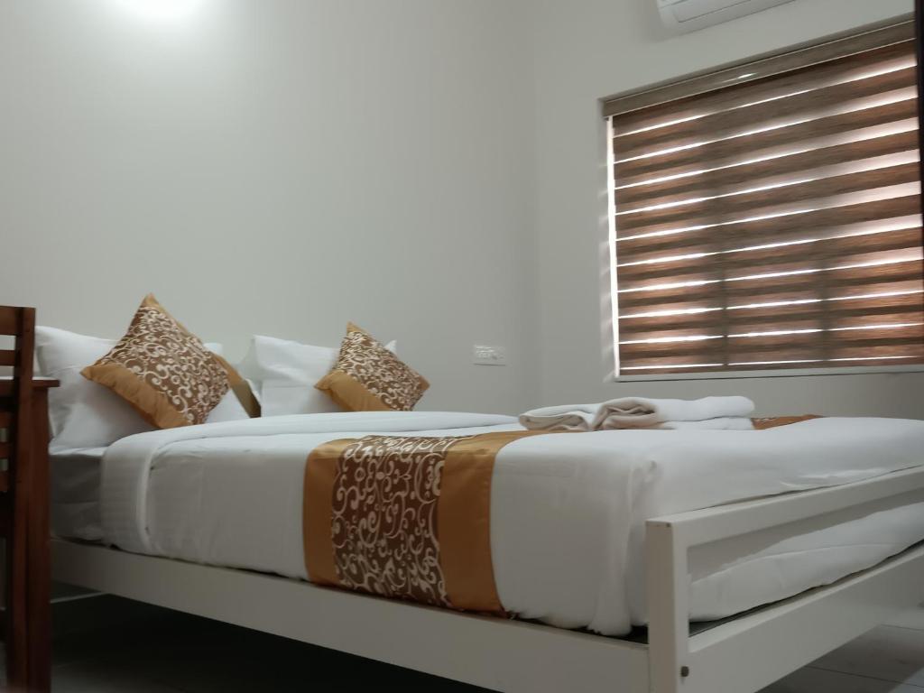 Postel nebo postele na pokoji v ubytování Greenview Royal Stay Near Amrita Hospital Edappally