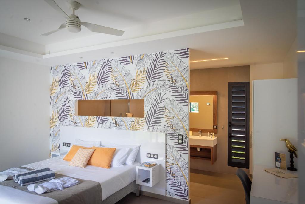 a bedroom with a large bed with a wall at Tropic &amp; Chic in Sainte-Anne