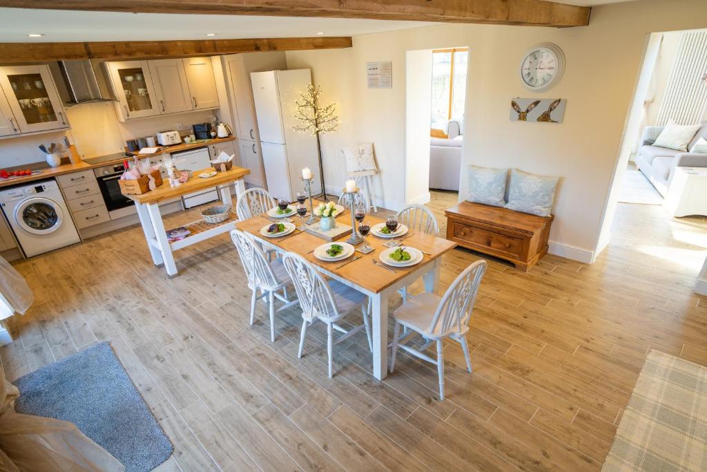 a kitchen and living room with a table and chairs at The Granary at Red House Farm in Stradbroke