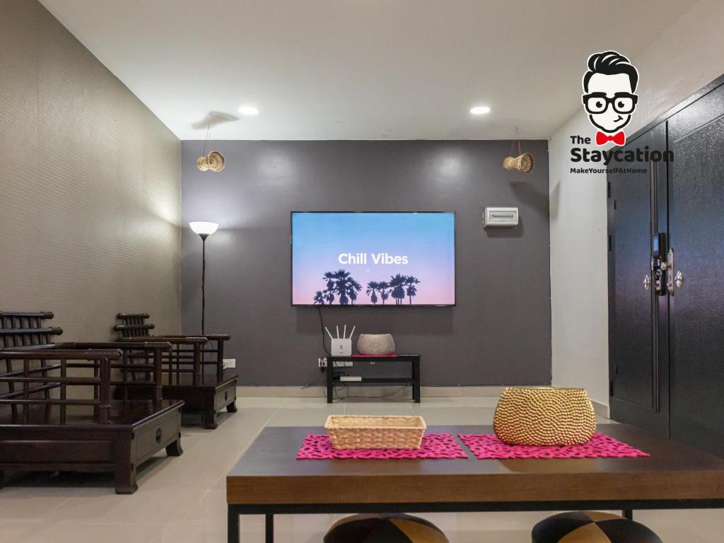 a living room with a tv on a wall at Staycation Homestay 40 Tranquil Haven Stephen Yong in Kuching