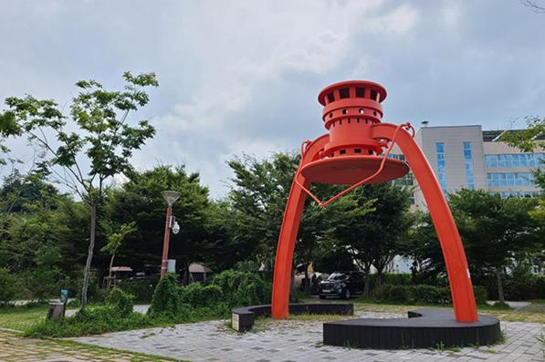 a large red object is sitting in a park at Byeonsan Auto Camping in Buan
