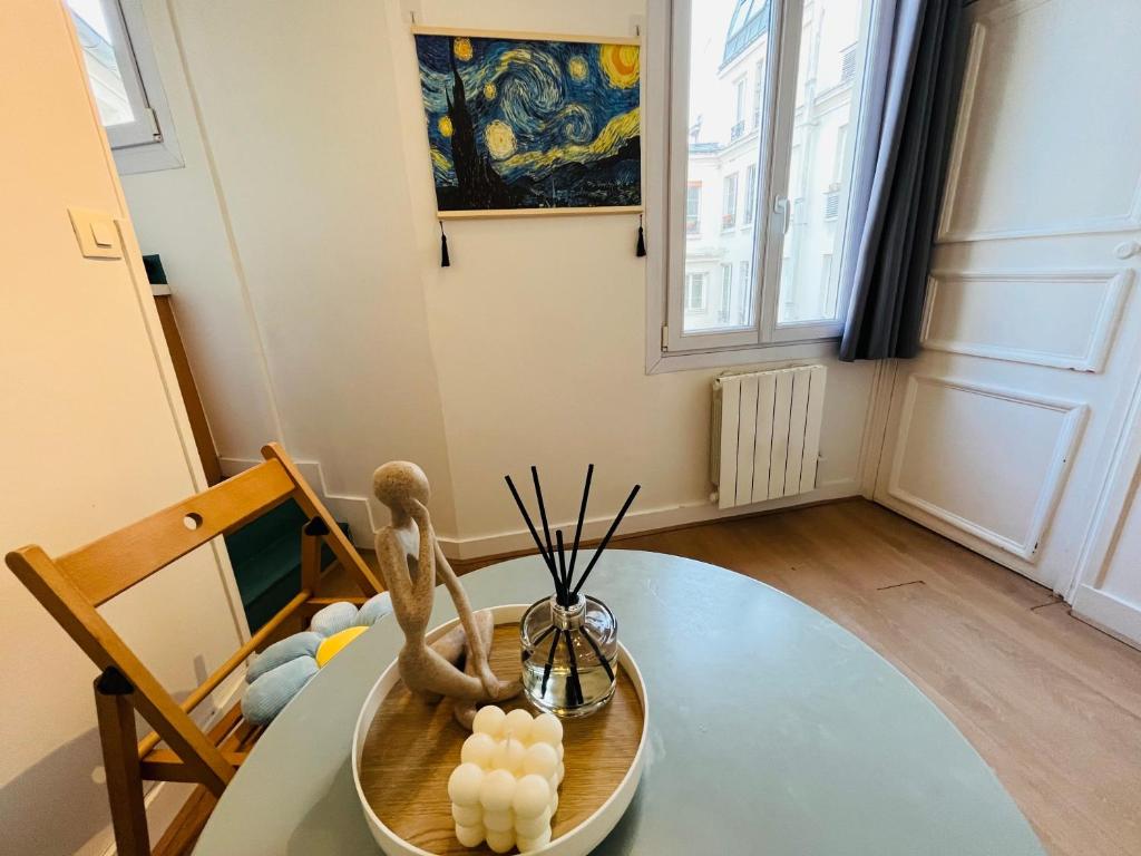 Cette chambre dispose d'une table avec une statue. dans l'établissement Dream Dwell Paris- 650m to Notre Dame Apartment near Odéon, à Paris