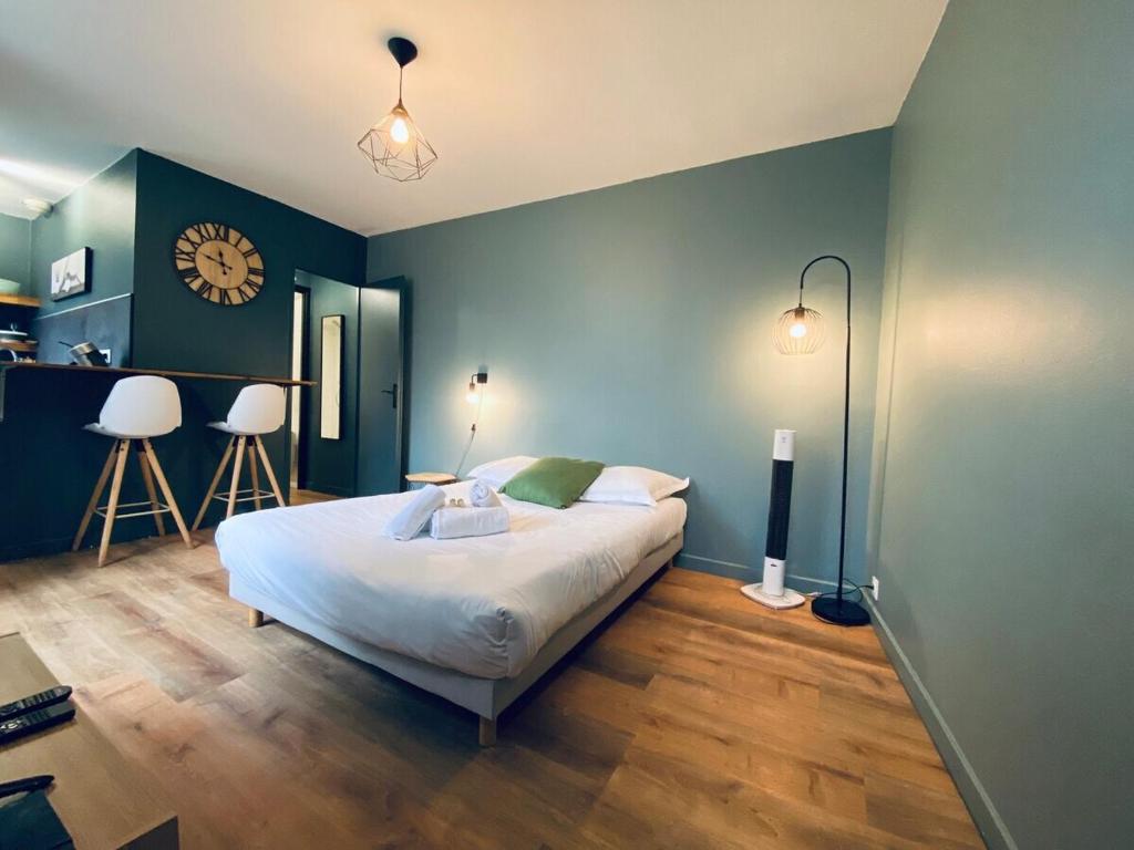 une chambre avec un lit et une horloge au mur dans l'établissement Casa Balzac - Studio, à Angers