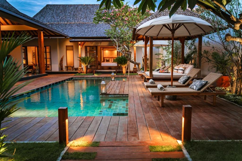 une cour arrière avec une piscine et une maison dans l'établissement Villa Zarrin Seminyak Bali Luxury 3 bedroom villa, à Seminyak