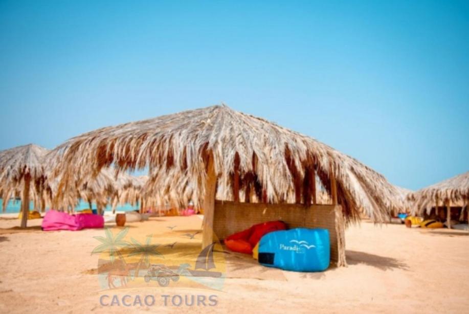 a straw hut on the beach with someones belongings at Paradise island in Hurghada