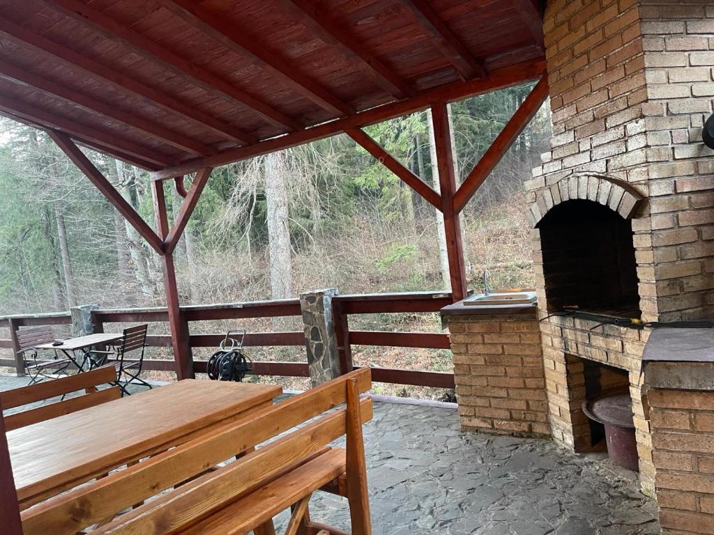 a patio with a wooden bench and an outdoor oven at CAMERE de INCHIRIAT LA TUGUIATA in Buşteni