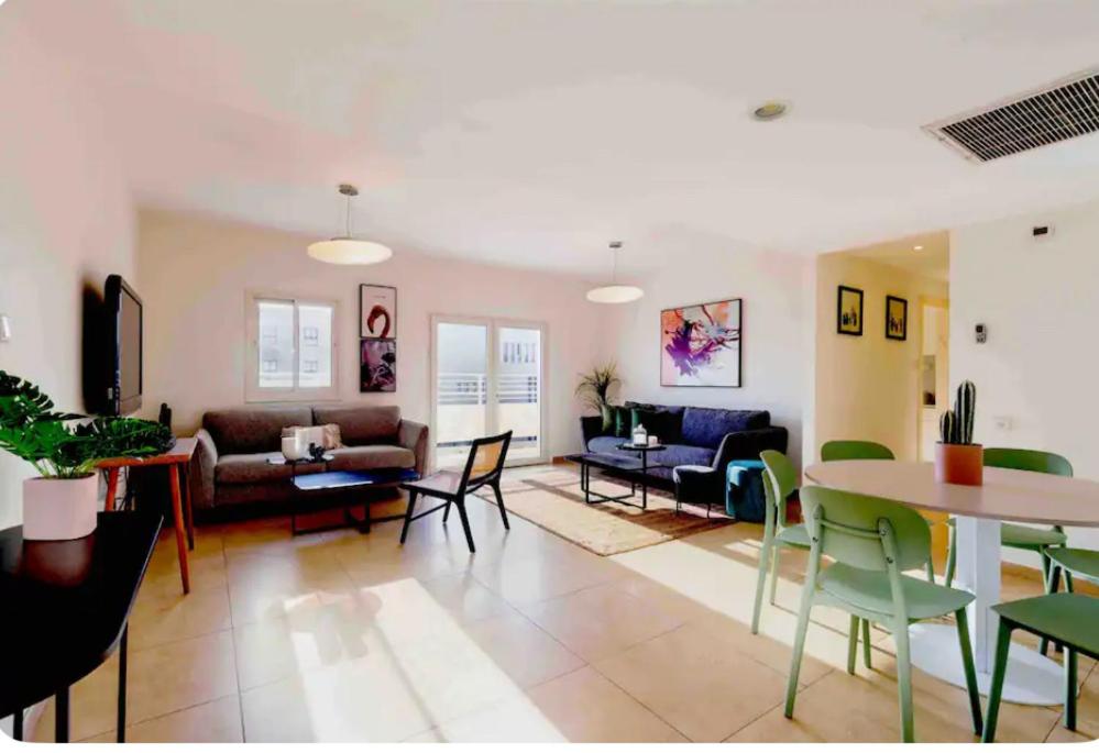 - un salon avec un canapé, une table et des chaises dans l'établissement Apartment in Rehavia Jerusalem, à Jérusalem
