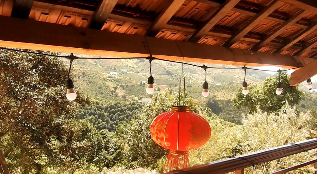 a red lantern hanging from a roof with a view of a mountain at Farm cô chú Tuấn Hà in Da Lat