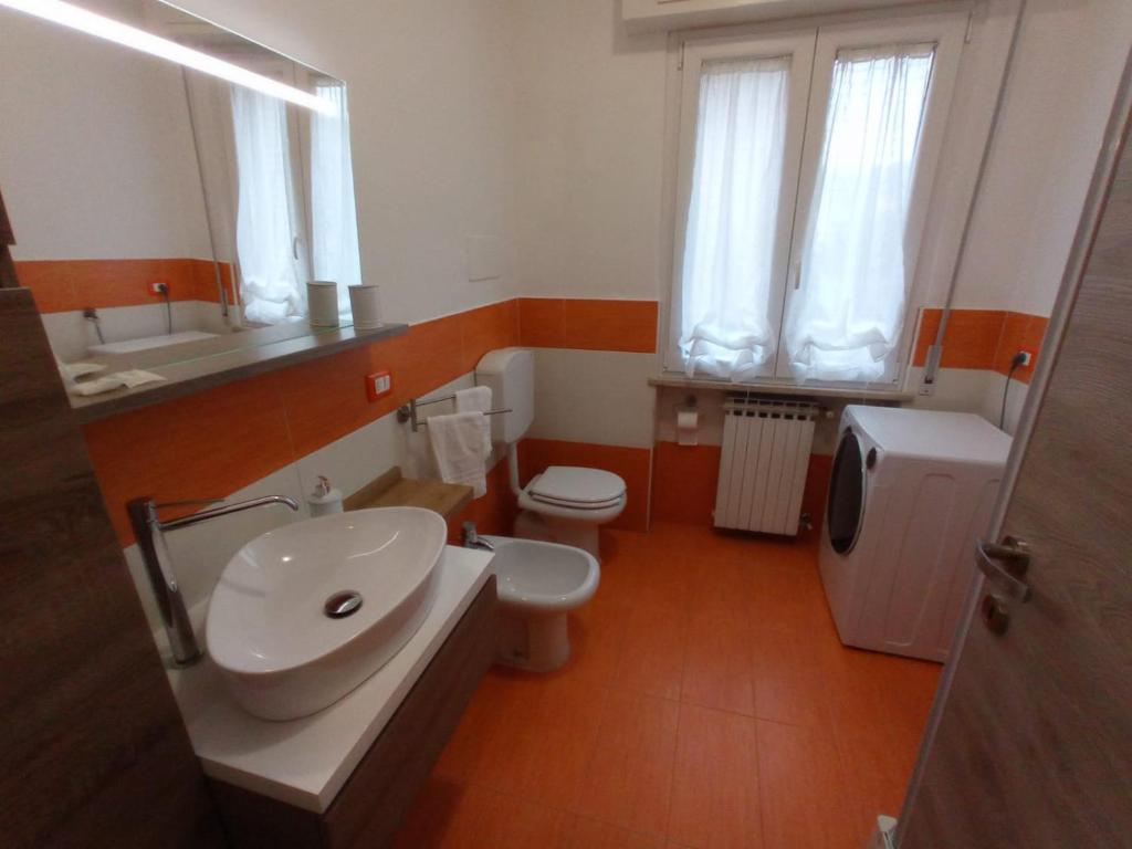bagno con lavandino, servizi igienici e specchio di Casa Romolo a Garda
