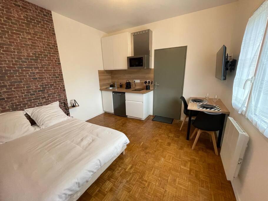 a bedroom with a bed and a desk and a kitchen at Studio & Coworking Thème Factory A in Morsang-sur-Orge