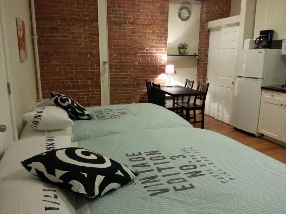 Duas camas num quarto com uma cozinha em Midtown Nest Studio Self Serviced Apartment Sleeps 5 em Nova York