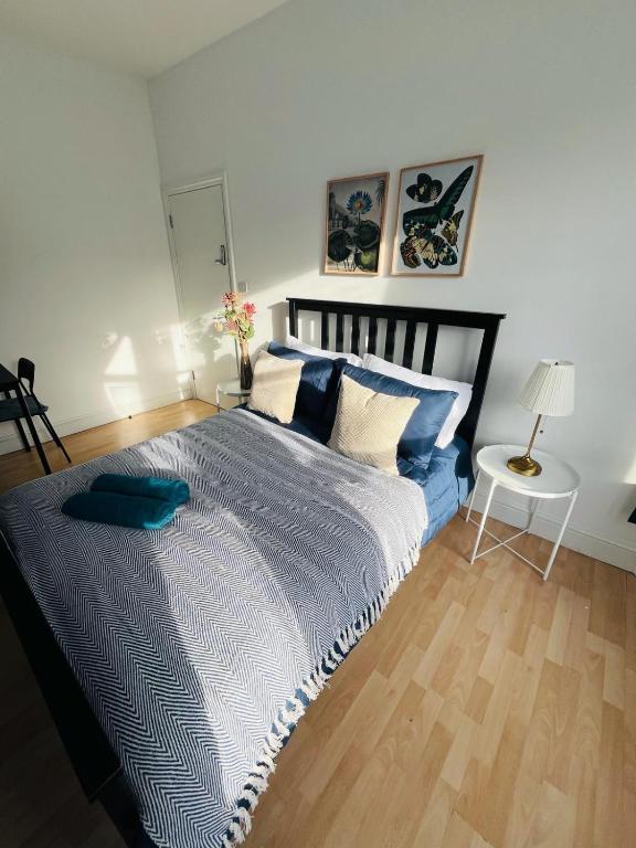 a bedroom with a large bed with blue sheets and pillows at Stay and Explore Easy Central London Access via Jubilee Line in London