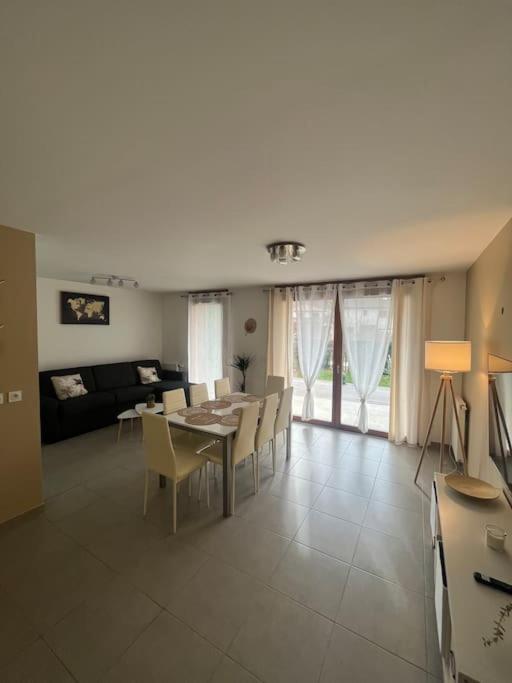 a large living room with a table and chairs at Maison avec terrasse et garage proche tram in Gières