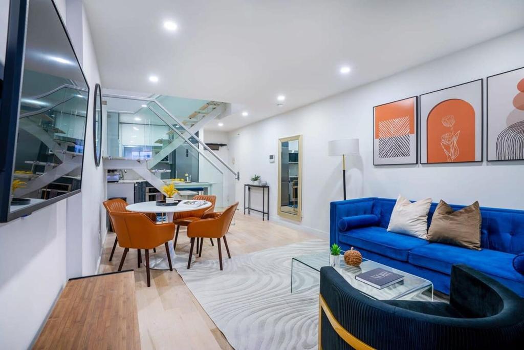 ein Wohnzimmer mit einem blauen Sofa und einem Tisch in der Unterkunft 75-3B 3BR Luxury duplex BRAND NEW &D Elevator in New York