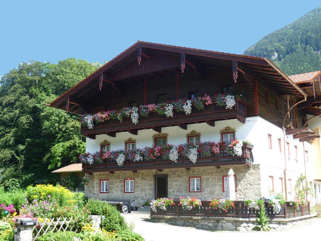 een gebouw met bloembakken aan de zijkant bij Bauernhof Auerhof Ferienwohnung in Aschau im Chiemgau
