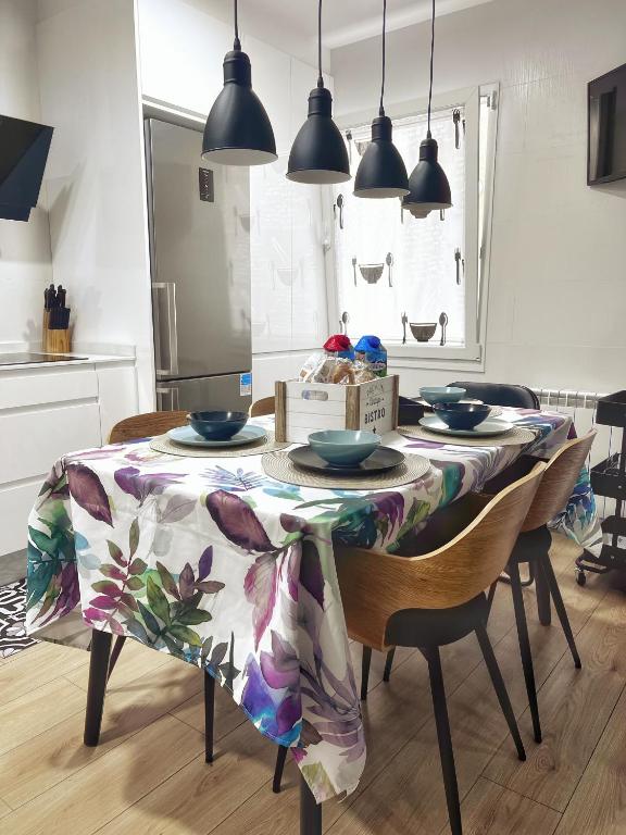 una mesa de comedor con un mantel de flores. en TU CASA - Parking y terraza VUT 177-AS, en Gijón