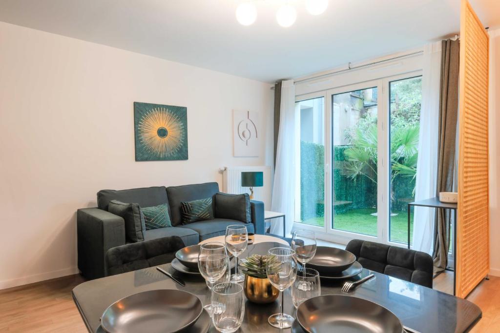 un salon avec une table et un canapé dans l'établissement Flat with Garden - 1BR-4P - Montreuil, à Montreuil