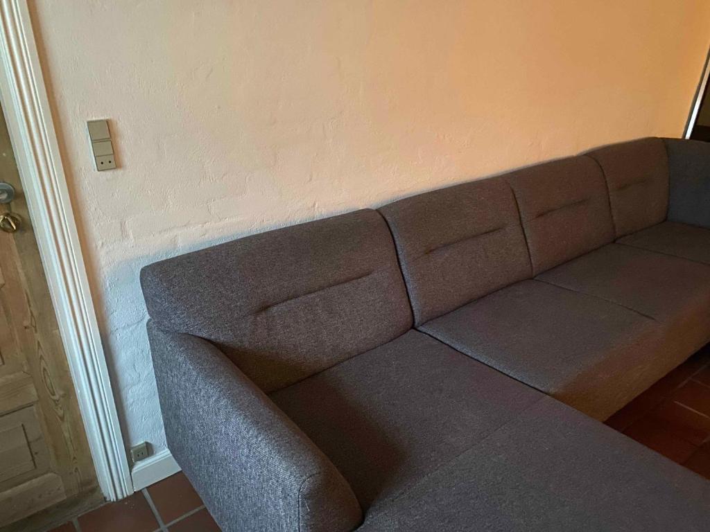 un sofá contra la pared en la sala de estar en Cozy Summer House In Svenborg, en Svendborg