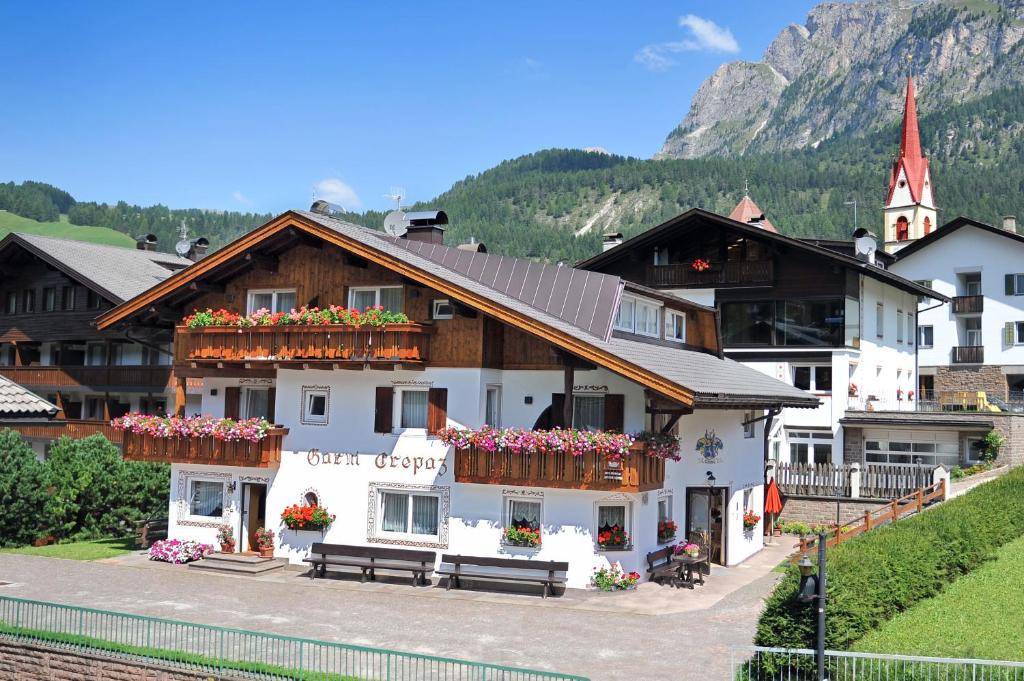 a white building with flower boxes on its windows at Garni Crepaz in Selva di Val Gardena