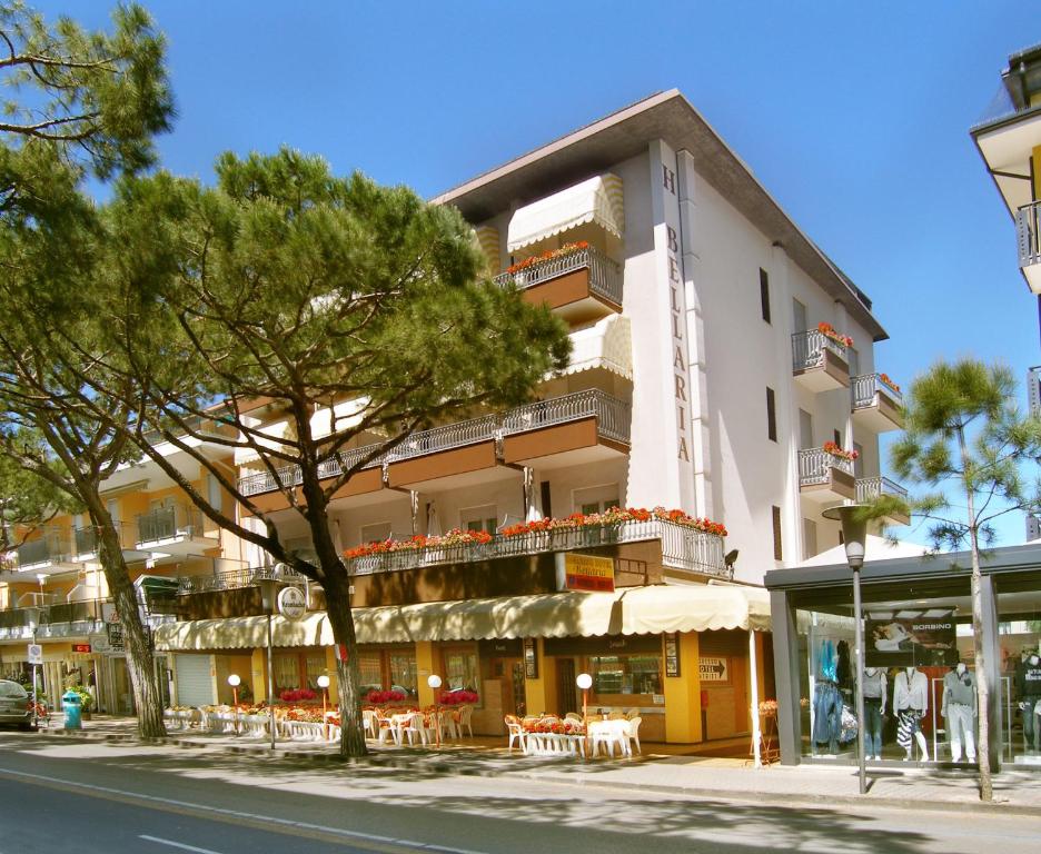 a building with tables and chairs on a street at Hotel Bellaria in Lido di Jesolo