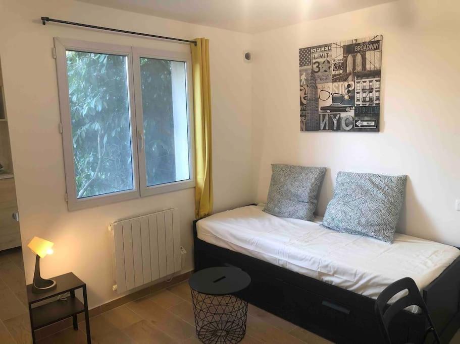 un petit lit dans une chambre avec une fenêtre dans l'établissement Cosy studio, à Saint-Denis