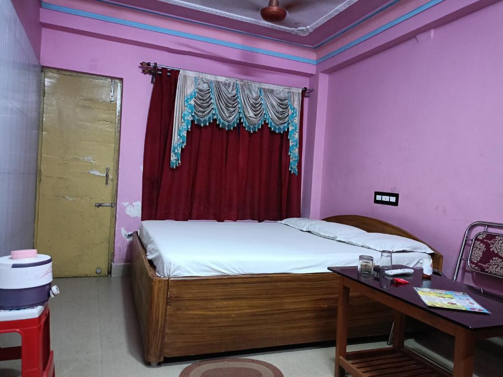 a bedroom with a bed and a table and a window at Near Sea Beach Purbasha in Digha