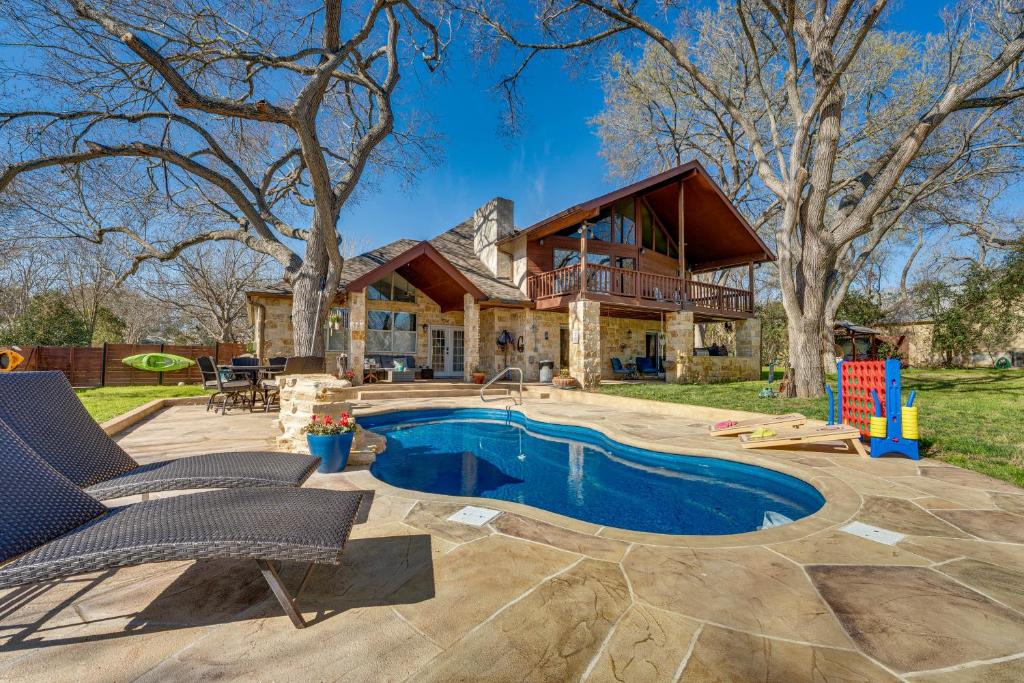 a house with a swimming pool in front of a house at Seguin Riverfront Retreat Fishing Dock and Kayaks! in Seguin