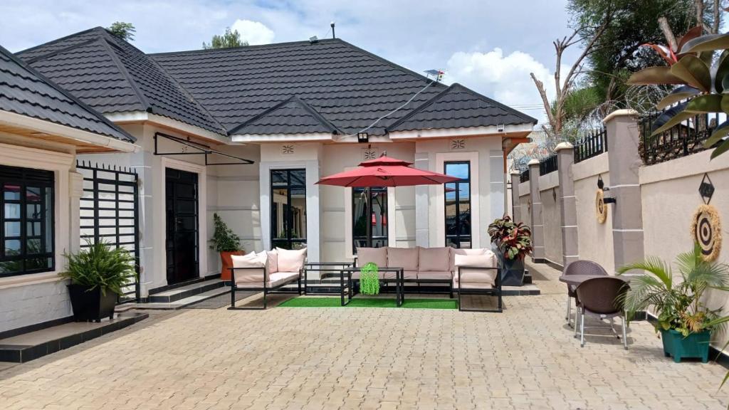 Casa con patio con sombrilla roja en Cacecy Luxury Homes 3 Bedroom, en Bungoma