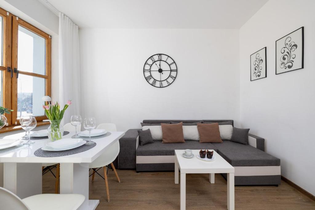 uma sala de estar com um sofá e uma mesa em Rynek Sienny Cosy Apartment em Szczecin