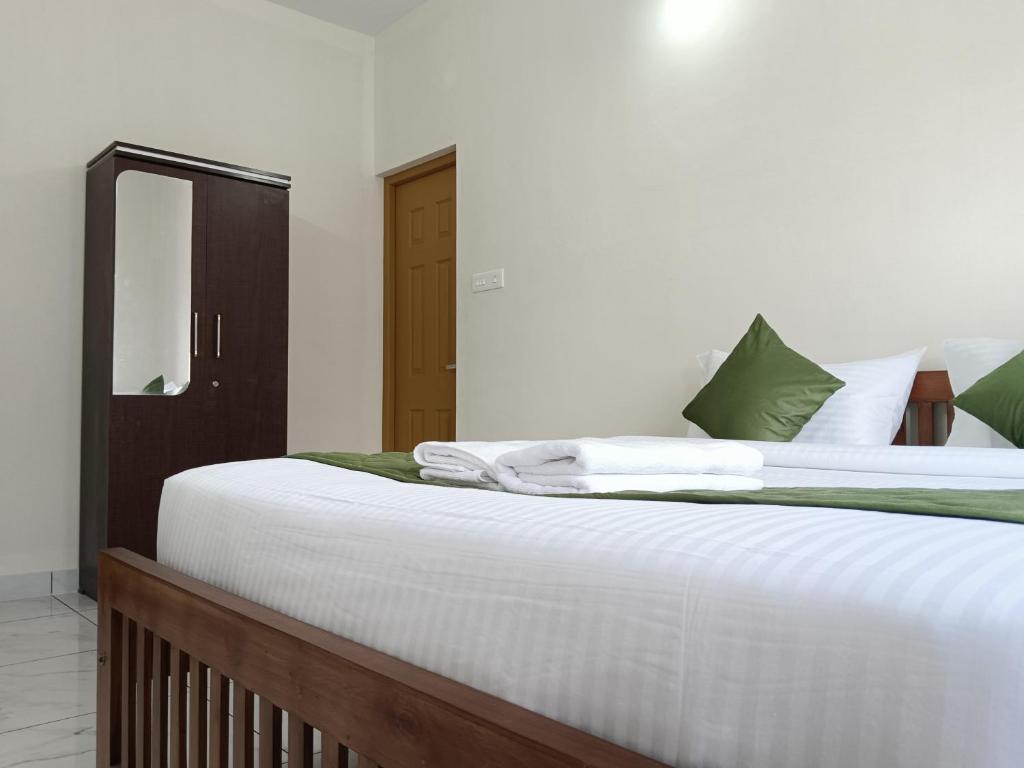 Postel nebo postele na pokoji v ubytování Greenview Royal Stay Near Amrita Hospital Edappally