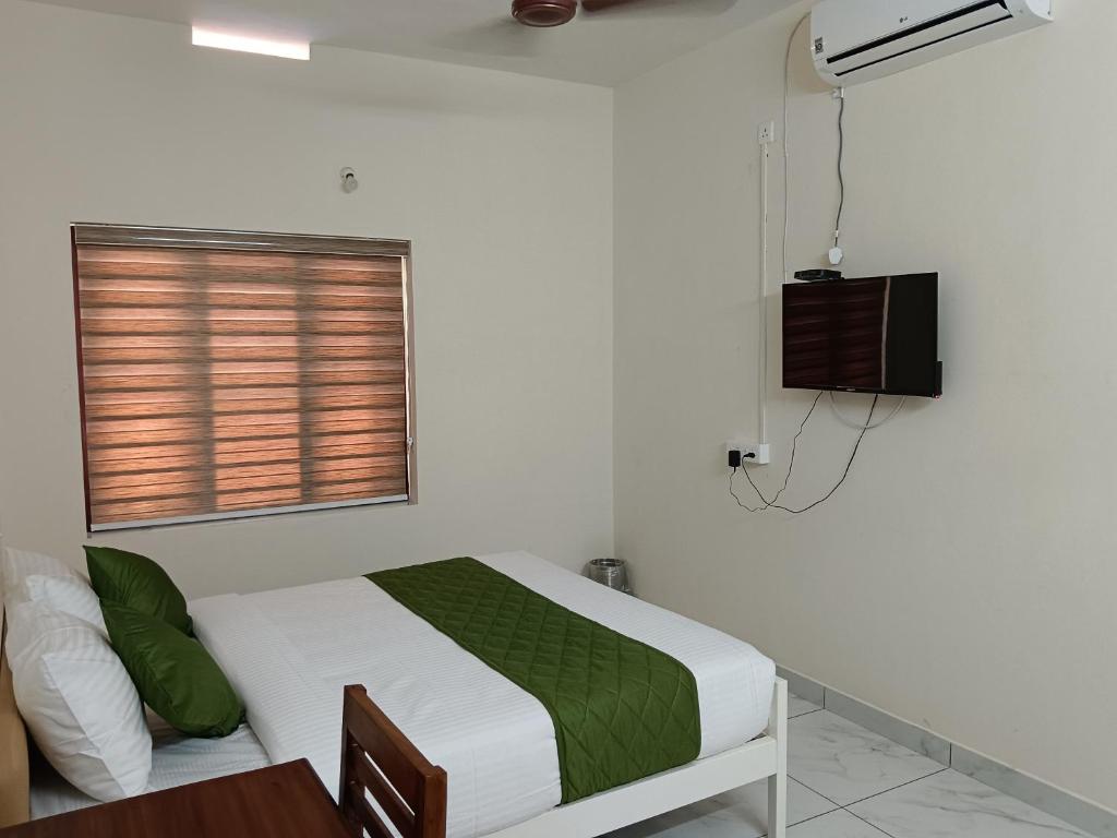 Postel nebo postele na pokoji v ubytování Greenview Royal Stay Near Amrita Hospital Edappally