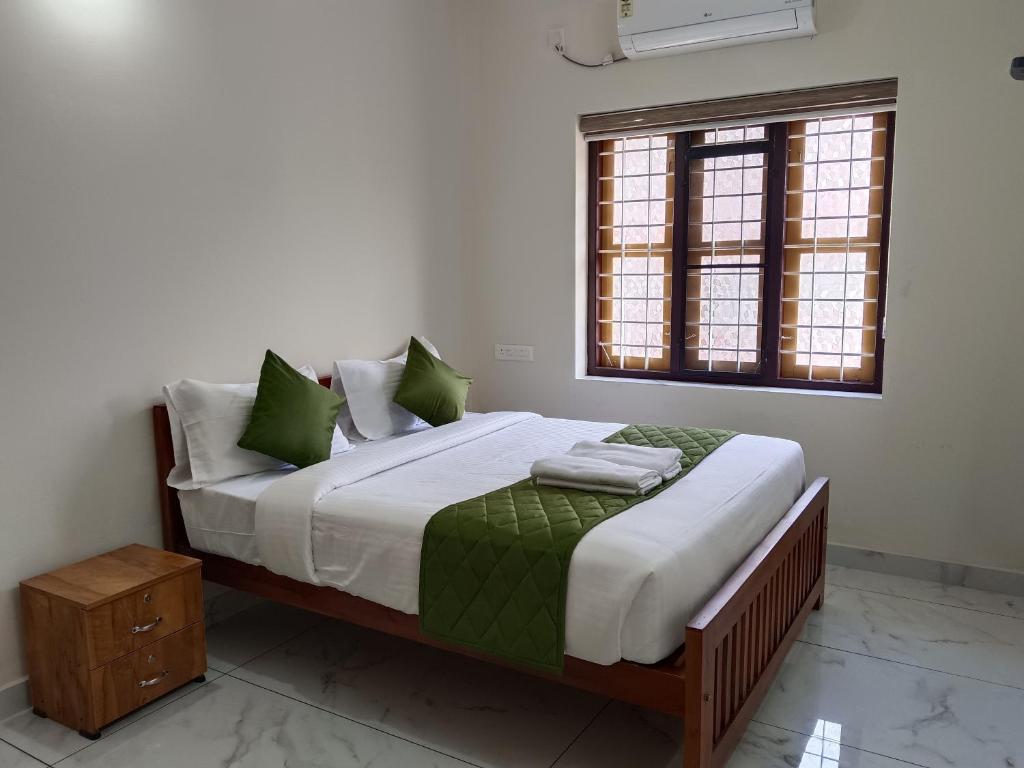 Postel nebo postele na pokoji v ubytování Greenview Royal Stay Near Amrita Hospital Edappally