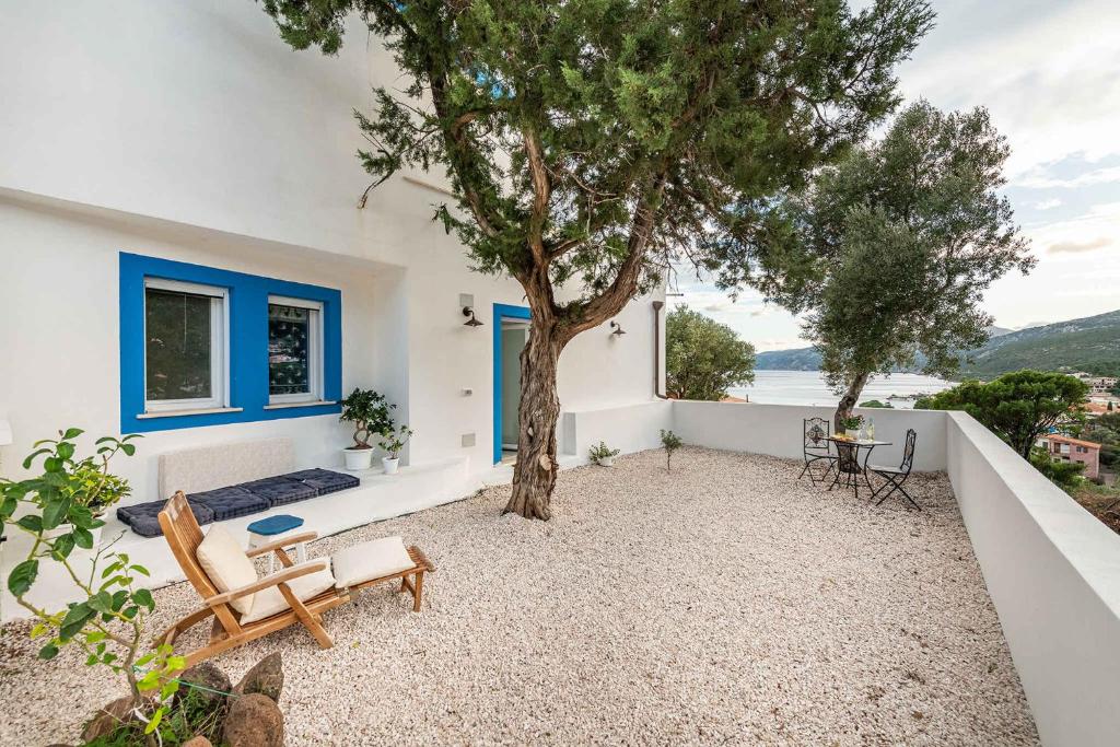 a patio with a tree and a table and chairs at Apartment in Cala Gonone - Nuoro (Provinz) 48226 in Cala Gonone
