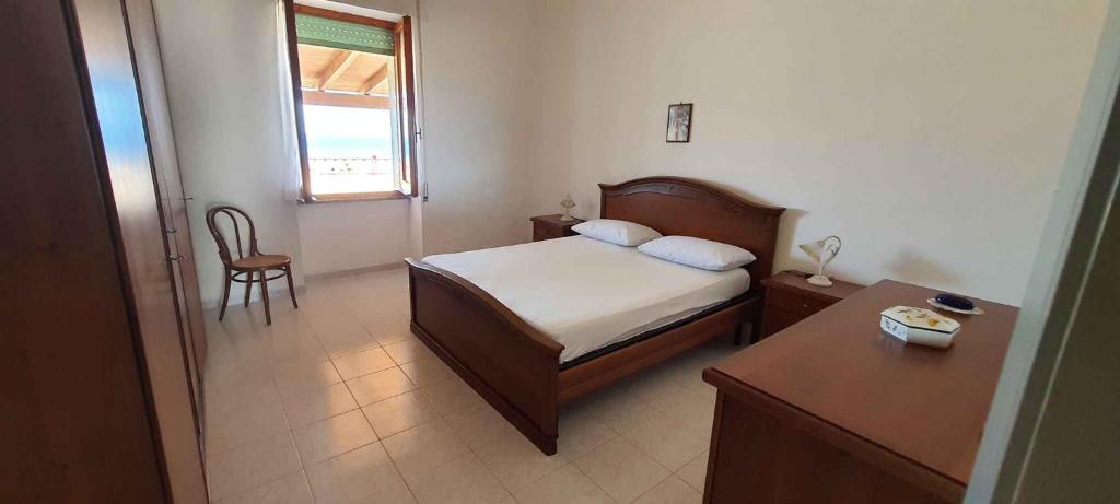 una camera con letto, tavolo e finestra di Apartment in Lu Bagnu 49206 a Castelsardo