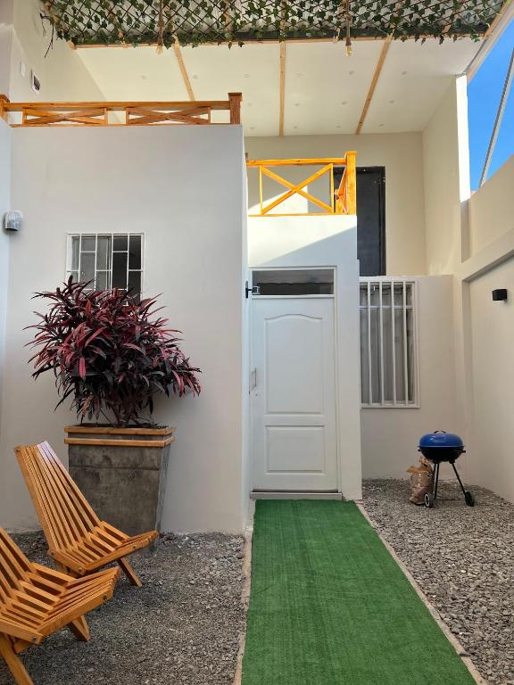 Habitación con puerta blanca y suelo verde en Casa Apartament Paseo Del Mar en Chimbote