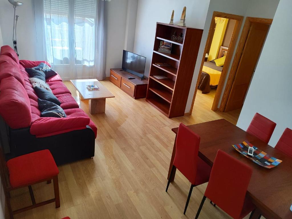 sala de estar con sofá rojo y mesa en San Miguel, en Membrilla