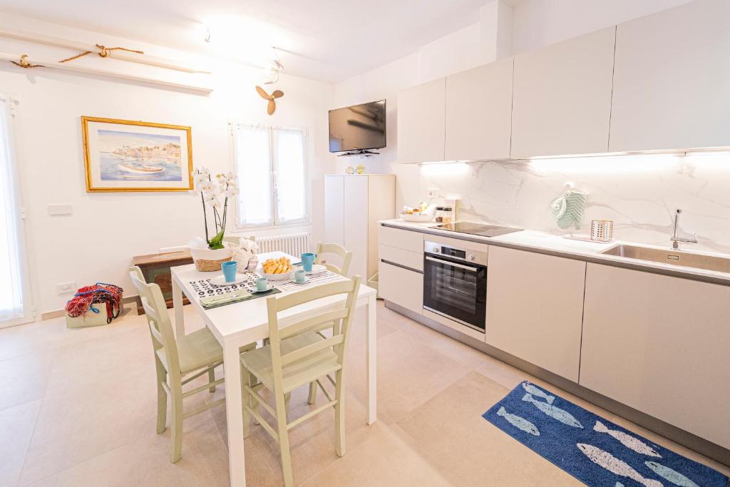 una cocina blanca con mesa y sillas. en La Casetta del Bistromare, en Sestri Levante