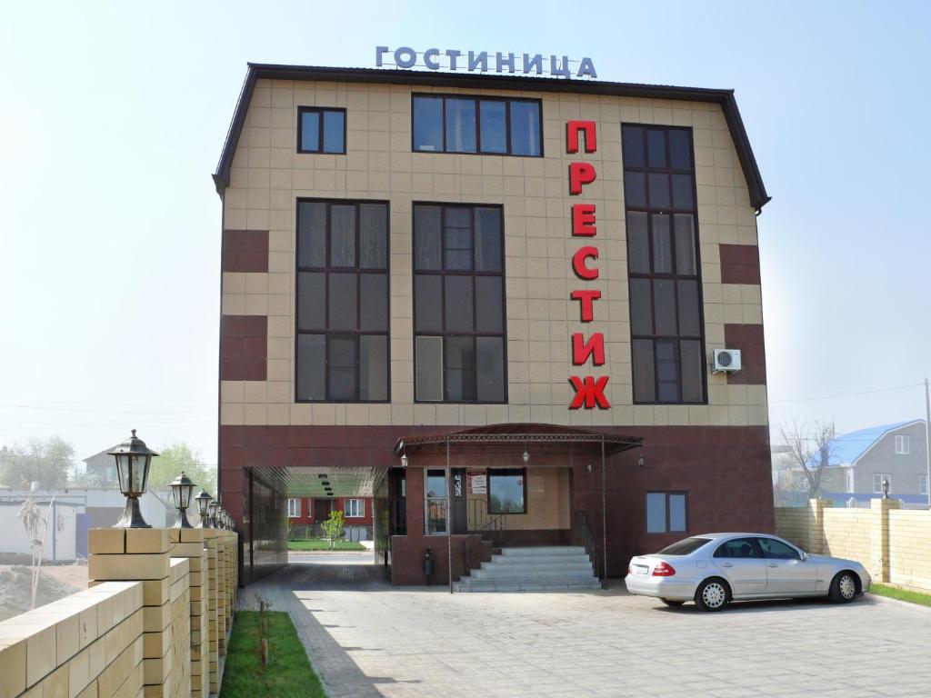 een gebouw waar een auto voor geparkeerd staat bij Hotel Prestige in Astrachan