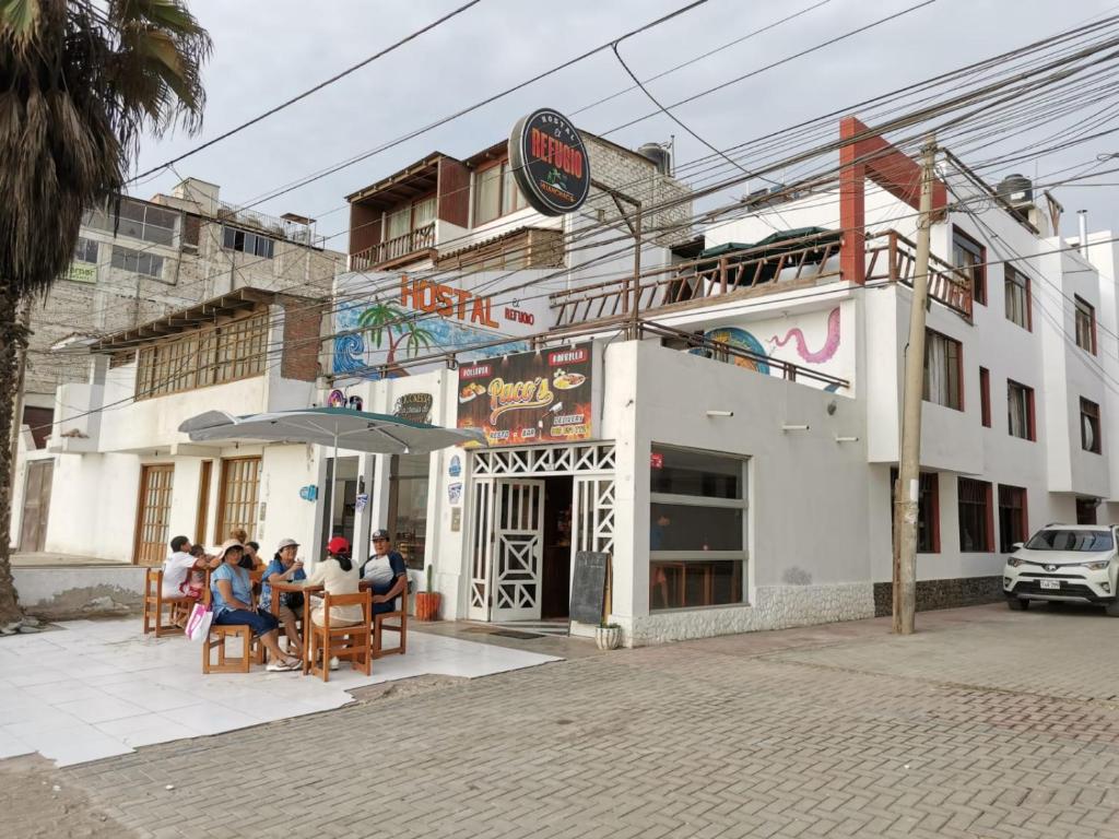 um grupo de pessoas sentadas fora de um edifício em HOSTAL EL REFUGIO em Huanchaco