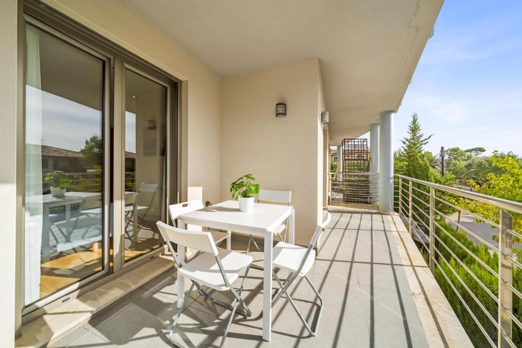 d'un balcon avec une table et des chaises blanches. dans l'établissement Duplex Can Volanti, à Port de Pollença