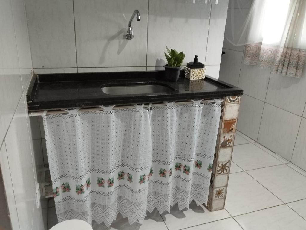 een badkamer met een wastafel en een douchegordijn bij Apartamento Aconchego 102 in Paulista