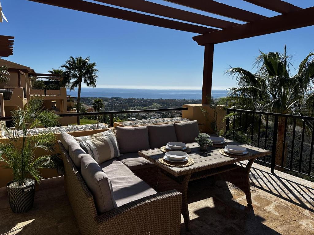 d'une terrasse avec un canapé et une table sur un balcon. dans l'établissement Charming 2 Bed Apartment in Quartiers Marbella, à Estepona