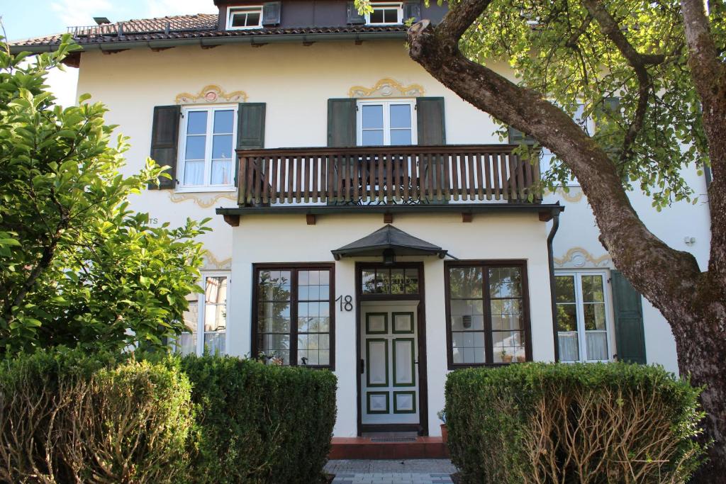 ein Haus mit Balkon darüber in der Unterkunft Villa Waldfrieden - Ferienwohnungen und -Haus in Kochel