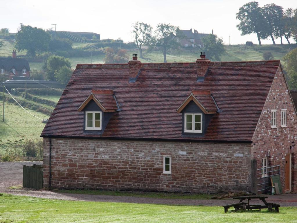 einem roten Backsteinhaus mit einem Tisch davor in der Unterkunft 2 Bed in Newthorpe 47031 