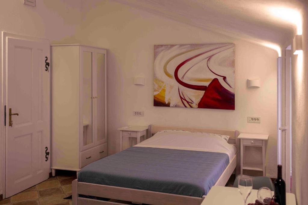 a bedroom with a bed and a painting on the wall at Pocco Andante in Dubrovnik