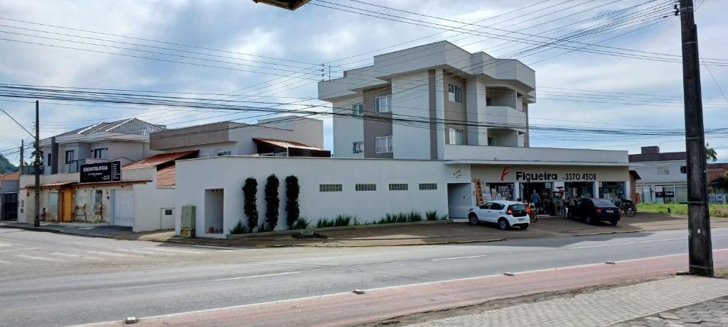 ein weißes Gebäude an der Straßenseite in der Unterkunft Apartamento 102 mobiliado 2 quartos Jaraguá do Sul-SC in Jaraguá do Sul