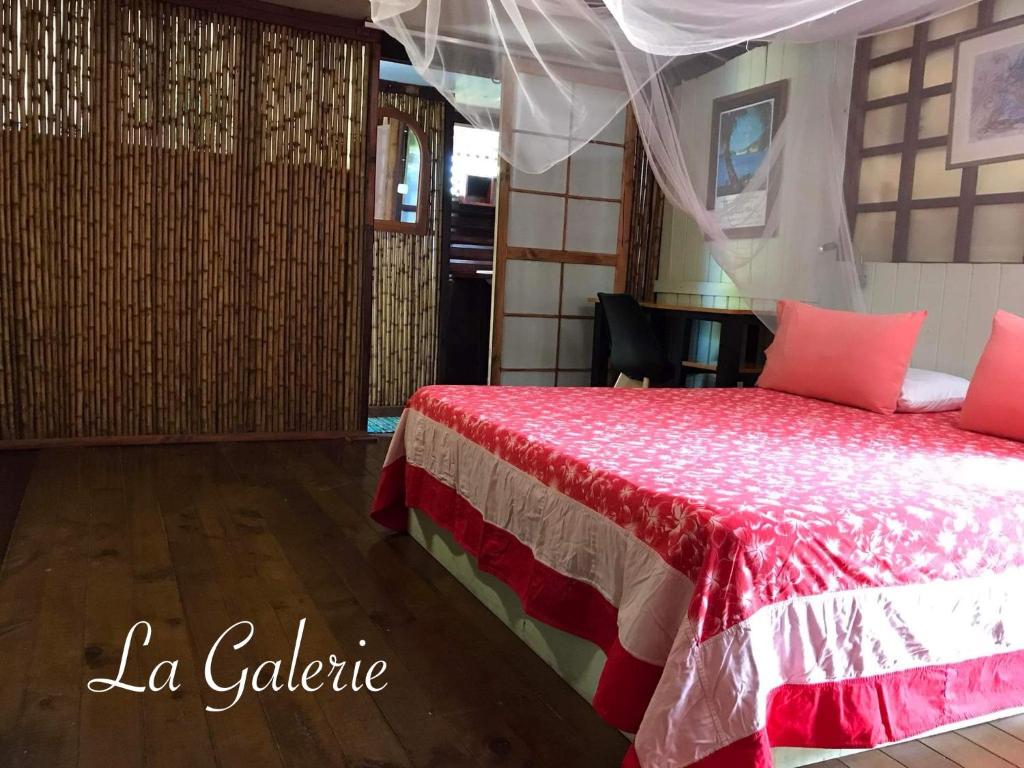 - une chambre avec un lit avec des draps rouges et une table dans l'établissement My Island Home, à Fare